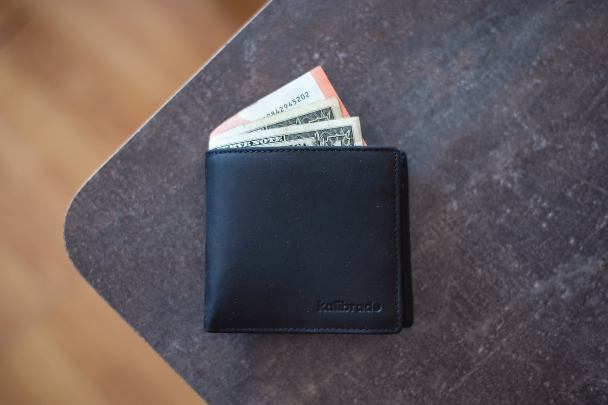 Dompet kulit hitam di atas tangan — ilustrasi cashback mingguan